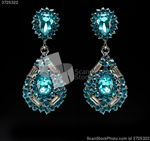 Image of earrings with blue stones on the black 