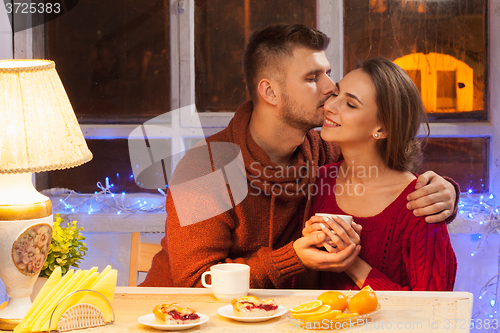 Image of The  happy young couple with cups of tea 