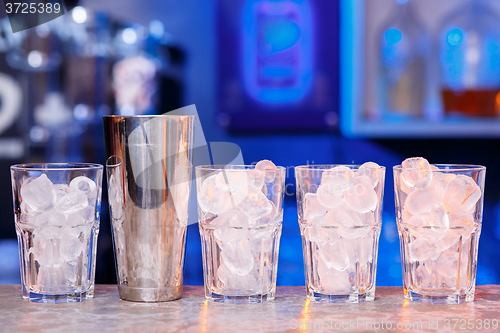 Image of Glasses with ice cubes on wooden table