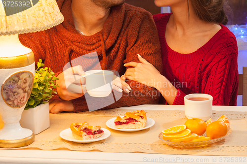 Image of The  happy young couple with cups of tea 