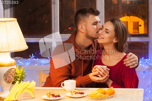 Image of The  happy young couple with cups of tea 