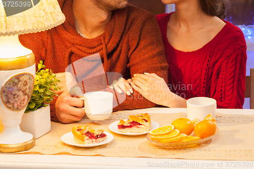 Image of The  happy young couple with cups of tea 