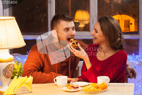 Image of The  happy young couple with cups of tea 