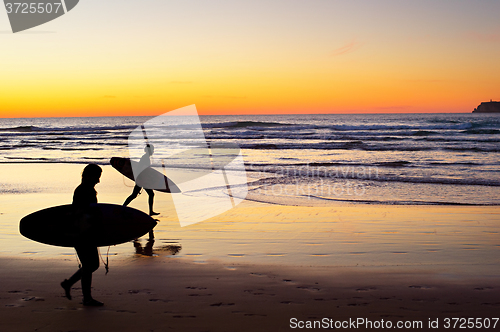 Image of Surfers at sunset, Portugal