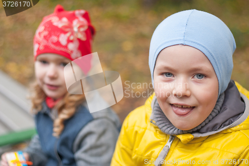 Image of two children in a park in autumn, portrait