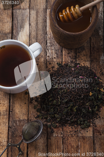 Image of The cup of tea and honey on a wooden table