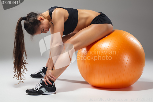 Image of The young, beautiful, sports girl doing exercises on a fitball 