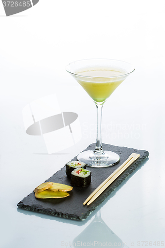 Image of Yellow cocktail with a set of sushi on white background