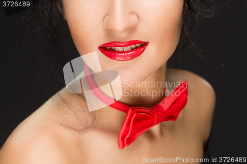 Image of close-up of bright red lips, tied around his neck the bow tie