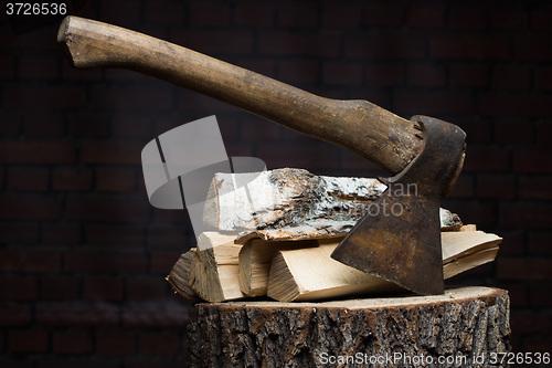 Image of birch firewood, old rusty ax 