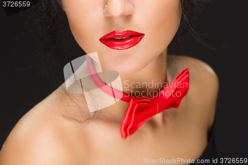 Image of close-up of bright red lips, tied around his neck the bow tie