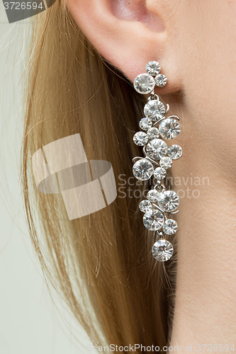 Image of close up of woman wearing shiny diamond earrings