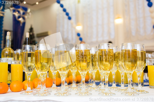 Image of Glasses with champagne on the party table. lot of alcohol