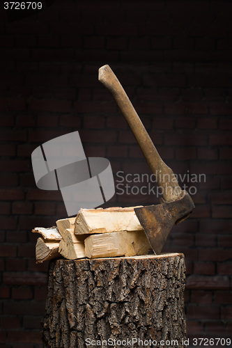 Image of birch firewood, old rusty ax 