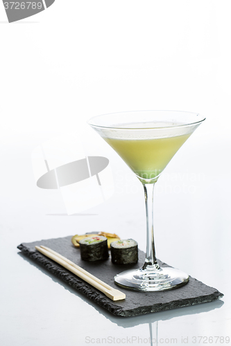 Image of Yellow cocktail with a set of sushi on white background