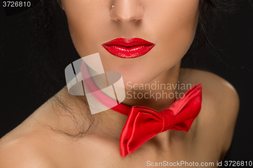 Image of close-up of bright red lips, tied around his neck the bow tie