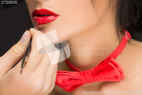 Image of Lips of a girl with artist doing makeup