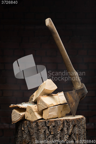 Image of birch firewood, old rusty ax 