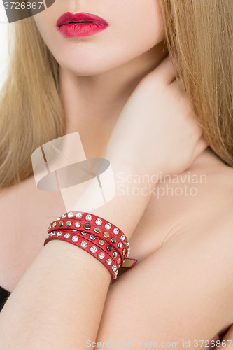 Image of hands close-up of a young girl with leather bracelet