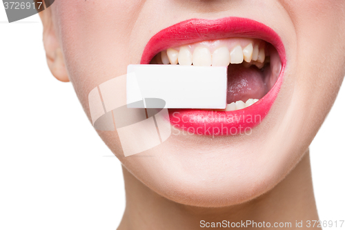 Image of girl holds in teeth white form. isolated