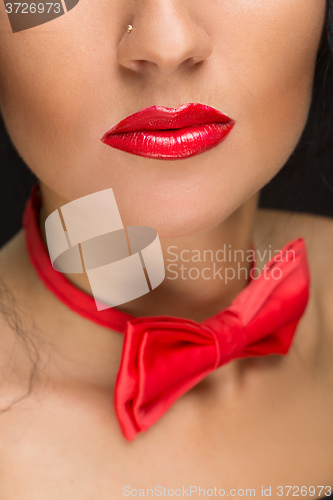 Image of close-up of bright red lips, tied around his neck the bow tie