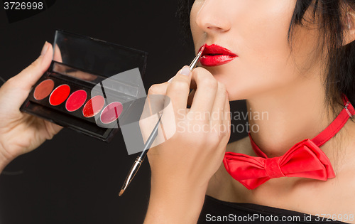 Image of Lips of a girl with artist doing makeup