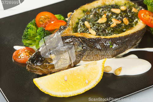 Image of Stuffed seabass on a black plate 