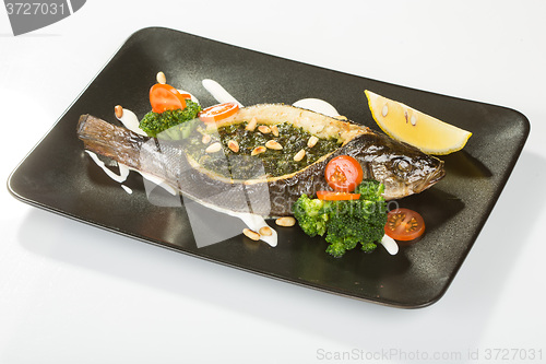 Image of Stuffed seabass on a black plate 