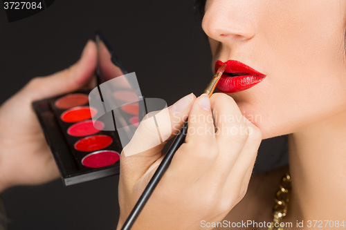 Image of Lips of a girl with artist doing makeup