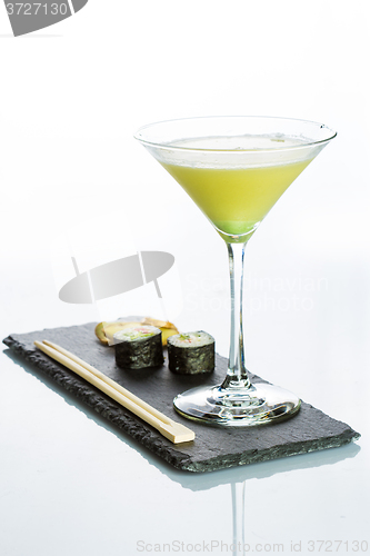 Image of Yellow cocktail with a set of sushi on white background