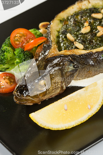 Image of Stuffed seabass on a black plate 