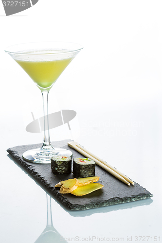 Image of Yellow cocktail with a set of sushi on white background