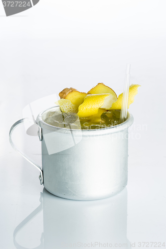 Image of Whiskey with ice in the iron circle isolated on white. lemon zest