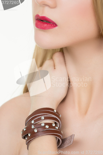 Image of hands close-up of a young girl with leather bracelet