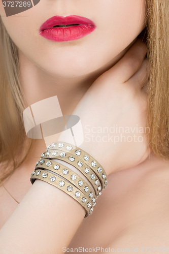 Image of hands close-up of a young girl with leather bracelet