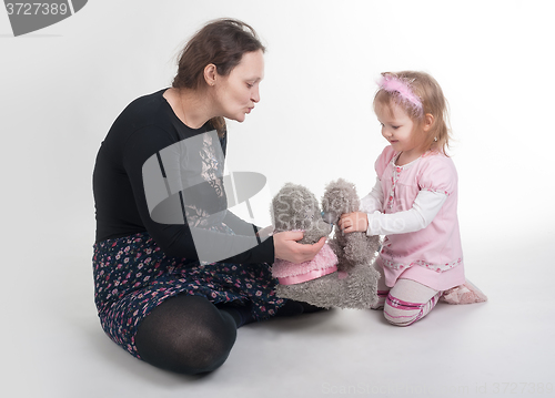 Image of Mother explains to daughter a kiss on toys