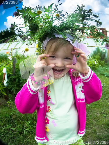 Image of Blond baby girl in wreath in home garden