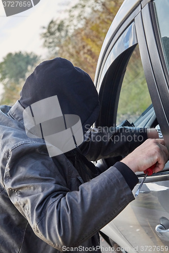 Image of Hooligan breaking into car