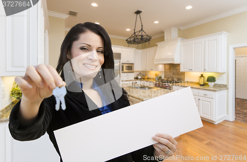 Image of Hispanic Woman In Kitchen Holding House Keys and Blank Sign