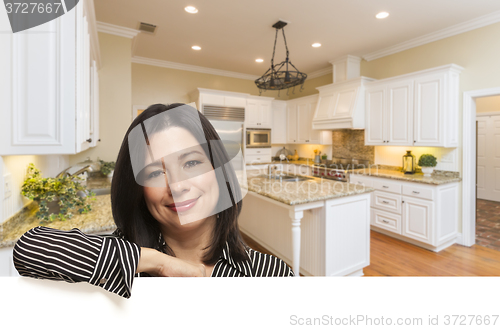 Image of Hispanic Woman Leaning Against White In Custom Kitchen Interior