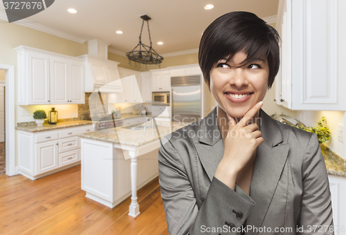 Image of Mixed Race Woman Looking Back Over Shoulder Inside Custom Kitche