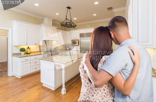 Image of Young Hopeful Military Couple Looking At Custom Kitchen