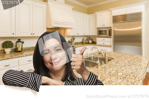 Image of Hispanic Woman with Thumbs Up In Custom Kitchen Interior