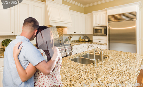 Image of Young Hopeful Military Couple Looking At Custom Kitchen