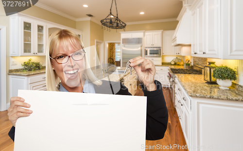 Image of Young Woman Holding Blank Sign and Keys Inside Kitchen