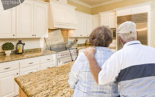 Image of Senior Couple Looking Over Beautiful Custom Kitchen