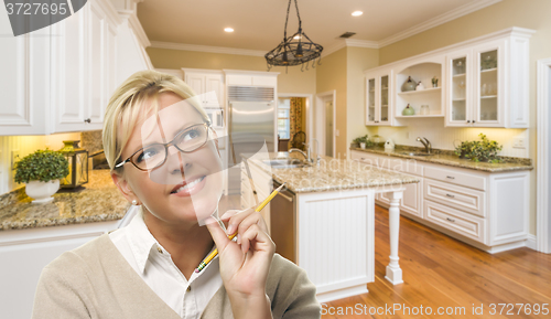 Image of Daydreaming Woman with Pencil Inside Beautiful Custom Kitchen