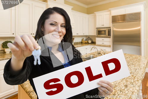 Image of Hispanic Woman In Kitchen Holding House Keys and Sold Sign