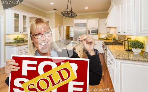 Image of Young Woman Holding Sold Sign and Keys Inside New Kitchen