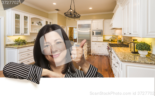 Image of Hispanic Woman with Thumbs Up In Custom Kitchen Interior